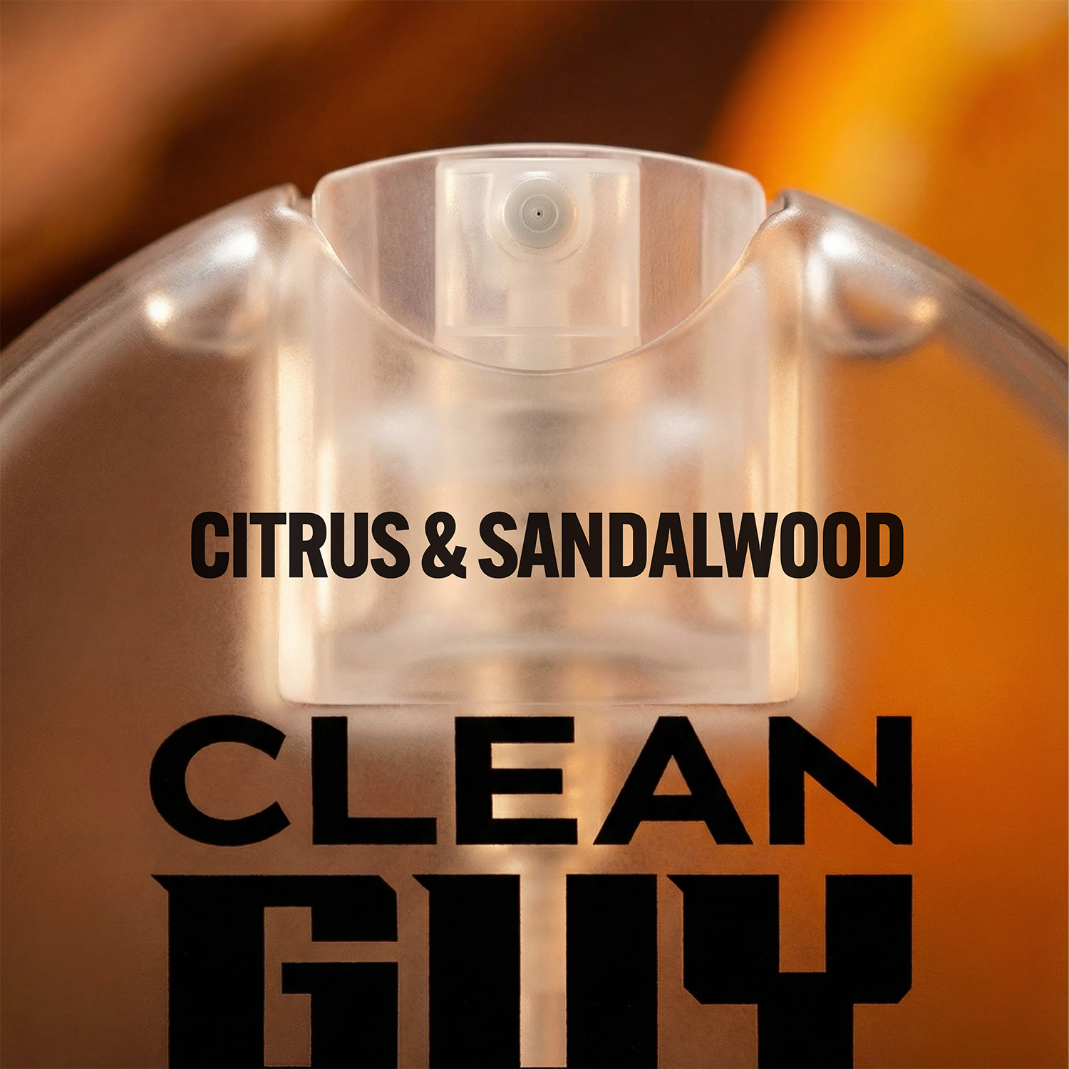 Clear perfume bottle with 'Citrus & Sandalwood' and 'Clean Guy' text on a blurred background