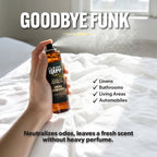 Hand holding a bottle of 'Clean Guy' linen and room spray on a bed with text about product uses and benefits.
